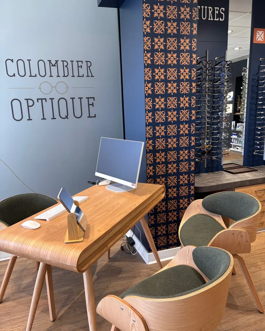 Le bureau de conseil, devant le mur au nom de Colombier Optique